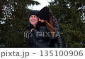 Happy romantic couple enjoying piggyback ride in winter forest 135100906