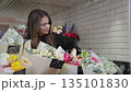 Woman choosing colorful bouquet at flower shop 135101830