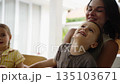 Close-Up of Mother Laughing and Hugging Her Son and Daughter at Home 135103671