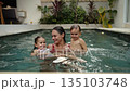Mother swimming and hugging her son and daughter in the pool at villa  135103748