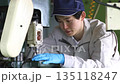 Young man working on a drill press in a factory 135118247