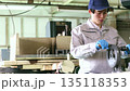A man processing parts with a hand drill 135118353