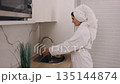 Woman bathrobe, Hydration health, Water benefits. In kitchen, woman wearing bathrobe partakes in healthy act drinking uncontaminated water. 135144874