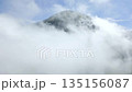 Aerial view of volcanic peak emerging above clouds in Central Java, Indonesia. Dramatic mountain landscape with mist, sky and natural atmosphere. 135156087