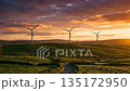 Wind turbines on green hills at sunset: Renewable energy and nature landscape. 135172950