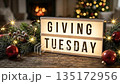 Giving Tuesday text on lightbox with Christmas decorations and fairy lights. 135172956