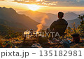 夕日に染まる絶景キャンプ：広大な連峰を望む至福のコーヒータイム 135182981