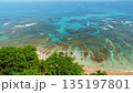 Shallow coastal waters with coral patterns in turquoise ocean under sunny sky 135197801