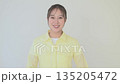 A young Japanese woman looking at the camera and making a fist pump on white background 135205472