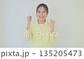 A young Japanese woman looking at the camera and making a fist pump on white background 135205473