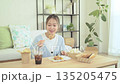 Young Japanese woman eating bento in the living room 135205475