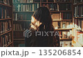 図書館で本を読む女性の後ろ姿に差し込む光 135206854