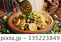Steaming authentic Moroccan chicken or lamb tagine being prepared and served  135223849