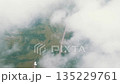 Aerial view of vibrant green landscapes in Russia, with clouds gently floating above 135229761