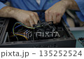 Technician man is diligently repairing computer 135252524