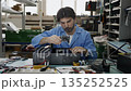 A man soldering technician wearing a blue shirt is diligently repairing computer 135252525