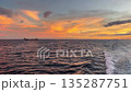 ocean sunset with vibrant orange and yellow skies, boat wake 135287751