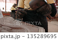 Close up of hands carve a traditional khmer apsara bas relief on stone in a workshop, using a chisel and mallet. Siem reap, Cambodia. 135289695