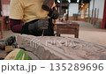 Close up of hands carve an stone bas relief design using a chisel and hammer to meticulously, Siem Reap, Cambodia. 135289696