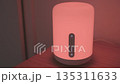 Smart lamp standing on a table smoothly changing colors. 135311633