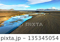 Glacial river in Iceland, Fast river flows between dunes of black volcanic sand, Nature water pattern 135345054