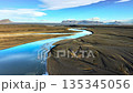 Glacial river in Iceland, Fast river flows between dunes of black volcanic sand, Nature water pattern 135345056