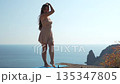 Woman, cliff, sea young woman posing on a cliff edge overlooking the beautiful ocean 135347805
