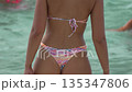 Woman bikini beach, rear view of body in shallow water on sunny day 135347806