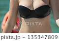 Woman bikini water, close up wet body in black swimsuit on sunny beach vacation 135347809