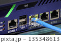 blue Ethernet cable connected to a gigabit network switch, showing active link lights for data transfer and internet networking technology 135348613