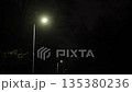 illuminated road, lamp series, park lighting. Streetlights aligned in row, glowing during night in park's roadway. 135380236