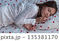 A 10-year-old girl sleeps sweetly in heart-shaped pajamas. High quality 4k footage 135381170