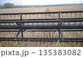 Close up rotating knifes of combine riding through countryside. Grain harvester working in field gathering crop of ripe wheat. View from inside cabin. Concept of harvesting. Slow motion 135383082