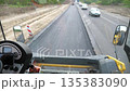 View on process of roadwork from inside cabin of steamroller. Roller laying new asphalt layer. Special machinery making road. Compactor constructing highway. Roadway repair by heavy machinery. Slow mo 135383090