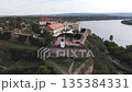 Travel concept. Aerial view of european city with architecture buildings and streets. Petrovaradin Novi Sad fortress along the Danube river. Vertical shot 135384331