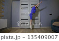 Caucasian girl 8 years old performing gymnastic exercise at home. Child fitness routine, active lifestyle, physical development of youth indoors. 135409007