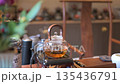 Elegant Kettle Boiling Tea With Flowers And Green Scenery 135436791