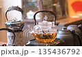 Elegant Kettle Boiling Tea With Flowers And Green Scenery 135436792