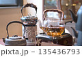 Elegant Kettle Boiling Tea With Flowers And Green Scenery 135436793