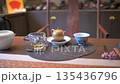 Close-Up View Of Steaming Tea With Teapot On A Circular Mat 135436796