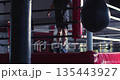 Slow motion cropped 4K footage of in the shadowy gym, the boxer's silhouette moves smoothly, skipping rope with power, rhythm, and fierce focus in every jump. 135443927