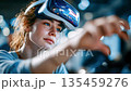 Female engineer wearing VR headset in a high-tech industrial environment, visualizing data and working with immersive technology 135459276