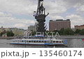 Russia, Moscow. Monument to Peter I celebrating the 300th anniversary of the Russian Navy with a passenger river cruise boat passing by, tourists on board, city and river view 135460174