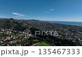 Aerial view over San Juan Capistrano, California, featuring the historic mission, library, sports courts, and an Amtrak train pulling into the downtown station. 135467333