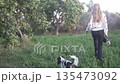 Beautiful Girl walking with her little dog in the park 135473092