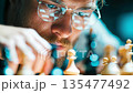 Focused chess player analyzing the board, symbolizing strategy, intelligence, concentration, and competitive thinking 135477492