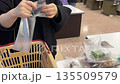スーパーで買った食材をビニール袋で包む様子（サッカー台) 135509579