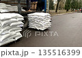 Forklift unloading pallet of sacks from truck. 135516399