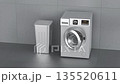Modern silver front load washing machine and laundry hamper in laundry room 135520611