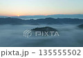 Amazing sunrise with fog flowing over mountains,Sunrise sky,Aerial view Drone flies over clouds 135555502